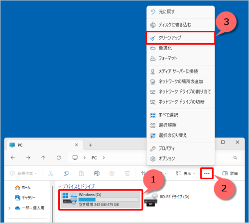 ディスククリーンアップを行うドライブをクリックし、画面上部メニューから「…」（もっと見る）をクリックして、表示された一覧から「クリーンアップ」をクリックします